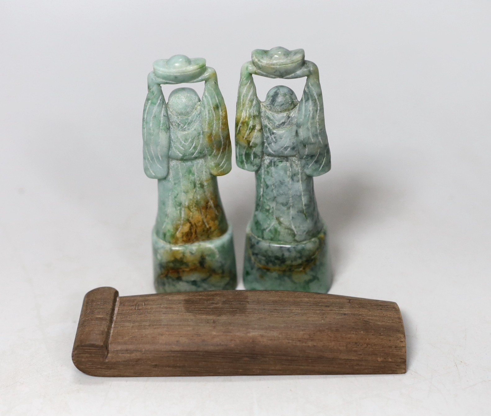 A pair of jadeite figural carvings and a gouged wood pan rest